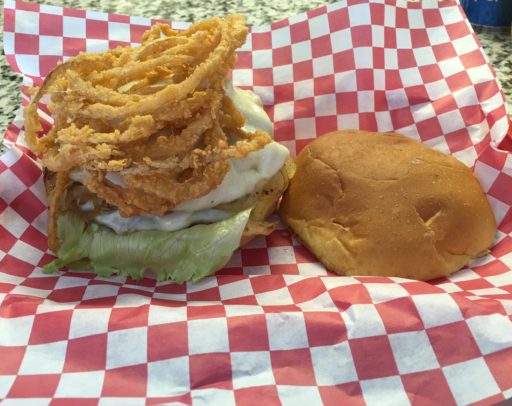 Burger topped with raw onion, grilled onion, and onion straws with your choice of cheese!